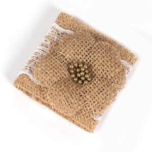 Rustic burlap napkin ring with white lace border and golden bead accents for wedding decor