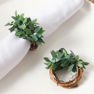 Handmade green leaf napkin rings with rustic brown rattan base for festive dining decor