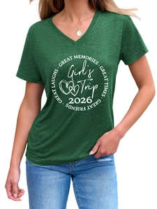 Détail d'un t-shirt vert à col en V avec impression blanche Girl's Trip 2026 au centre