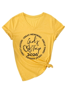 Détail d'un t-shirt jaune à col en V avec imprimé Girl's Trip 2026 et ourlet noué