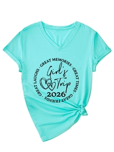Détail du t-shirt vert menthe à col en V avec imprimé Girl's Trip 2026 et nœud à l'ourlet