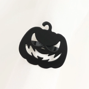 Dettaglio portatovagliolo a zucca in metallo nero con viso intagliato su tovagliolo