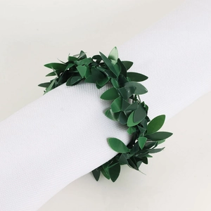 Faux green leaf napkin ring set on white linen for festive table decor and parties
