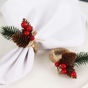 Detail of pine cones, red berries and needles on a twine napkin ring for Christmas