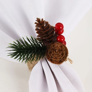 Christmas napkin ring with pine needles, cones, and red berries on a white fabric napkin