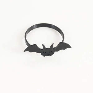Dettaglio dell'anello portatovagliolo a pipistrello in metallo nero con trame incise