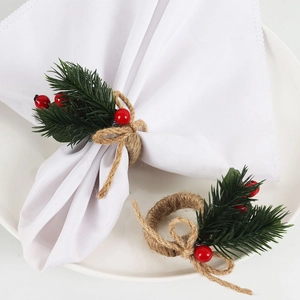 Detail of Christmas napkin ring with pine needles and red berries on a woven rope