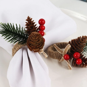 Christmas napkin ring set with pine needles, cones and red berries on a jute rope