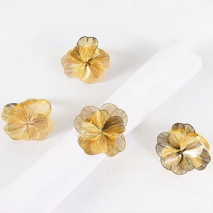 Dettaglio di set da 4 portatovaglioli a fiore dorato con design in filo metallico intrecciato