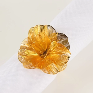 Dettaglio portatovagliolo a fiore dorato con petali in metallo spazzolato