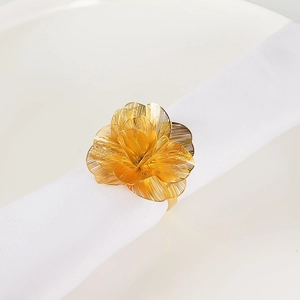 Dettaglio portatovagliolo dorato a fiori multistrato con texture in metallo spazzolato e 3D