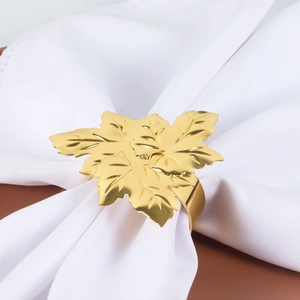 Elegant gold maple leaf napkin ring with detailed leaf veins on a white table napkin