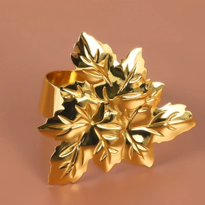 Close-up of golden maple leaf napkin ring showing intricate metallic leaf textures