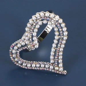 Elegant heart-shaped napkin ring with white pearls and iridescent rhinestones on silver base