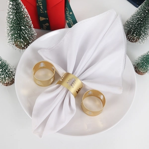 Matte gold Christmas tree napkin rings set on white napkin for festive table setting
