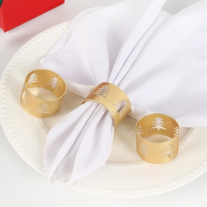 Detail of matte gold napkin rings featuring laser-cut Christmas tree design for table decor