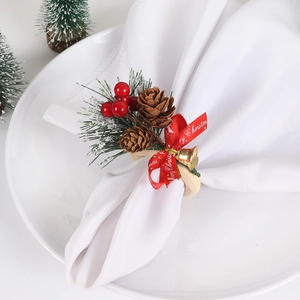Close-up of a Christmas napkin ring with wooden circle, red berries, and pine cones