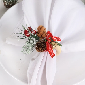 Christmas napkin ring with pine cones, red berries, gold bell, and Merry Christmas ribbon