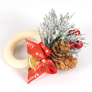 Christmas napkin ring with red bow, golden bell, pine cones and berries on wooden ring