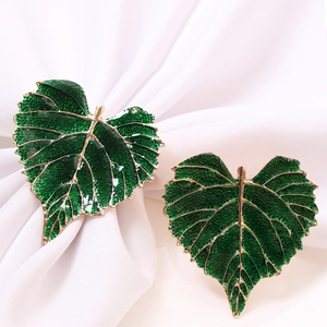 Elegant pair of gold-edged heart leaf napkin rings with textured green finish