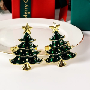 Detail of Christmas tree napkin rings with green enamel and gold star on white plate