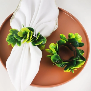 Handmade artificial green leaf napkin rings set on white napkin for dining table decor