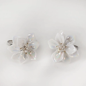 Acrylic floral napkin ring with iridescent white petals and diamond-studded gold center