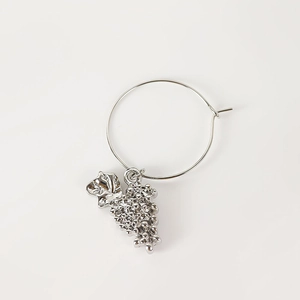 Detail view of silver metal wine glass ring featuring a textured grape cluster charm