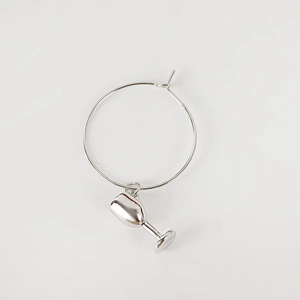 Detail of silver wine glass charm with polished hoop and creative metallic pendant