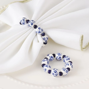 Blue and white porcelain beaded napkin ring with floral ceramic beads on white tray