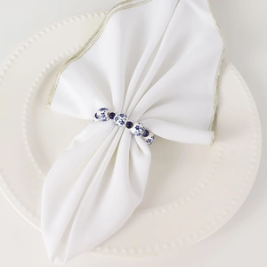 Blue and white porcelain bead napkin ring set on white ceramic plate for table decor