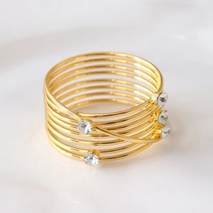 Elegant gold spiral napkin ring with four sparkling diamonds for luxury wedding table decor