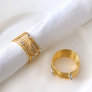 Detail of gold metal napkin ring featuring intertwined wires and sparkling crystal rhinestones