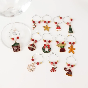 Close-up of 12 festive Christmas wine glass charms with tree and snowflake pendants