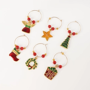 Macro view of Christmas wine glass charms featuring festive bells and star pendants