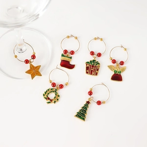 Detail of six festive Christmas wine glass charms with colorful holiday themed metal pendants
