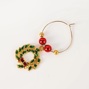 Detail of Christmas wine glass charm with green wreath pendant and gold ring beads