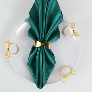 Polished gold bow-shaped metal napkin rings set of 4 for elegant dining table decor