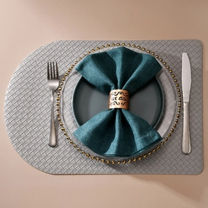 Detail of hollow gold napkin ring with Hebrew festive engraving on green napkin