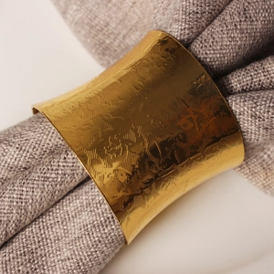 Golden metal napkin ring with hand-hammered texture and polished finish for table decor