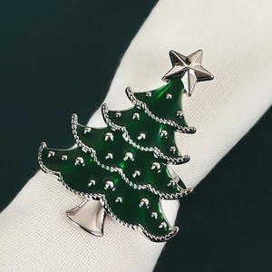 Silver Christmas tree napkin ring with green enamel finish on a white fabric napkin