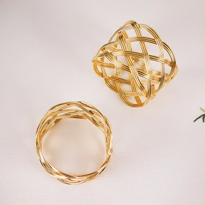 Detailed macro view of two woven gold wire napkin rings with hollow mesh structure