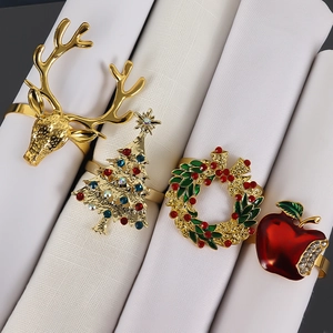 Close-up of gold reindeer, Christmas tree, wreath and apple rhinestone napkin rings