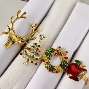 Set of four Christmas napkin rings featuring golden deer, xmas tree, wreath, and apple