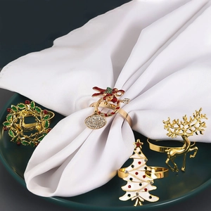 Détail de ronds de serviette de Noël festifs avec cerfs dorés et sapins blancs élégants