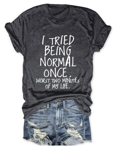 Détail du t-shirt gris foncé avec slogan 'I Tried Being Normal' et short en jean