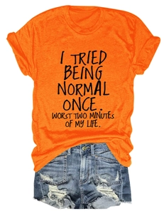T-shirt orange à texte associé à un short en jean bleu délavé présenté à plat sur blanc