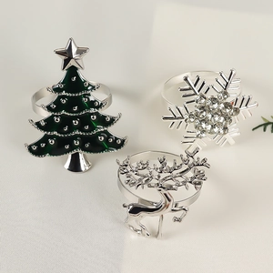 Detail of silver napkin rings featuring Christmas tree, snowflake, and reindeer designs