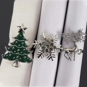 Detail of silver Christmas napkin rings featuring reindeer, snowflake and tree designs