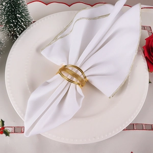 Détail du rond de serviette doré tissé à trois bandes sur une élégante assiette en porcelaine